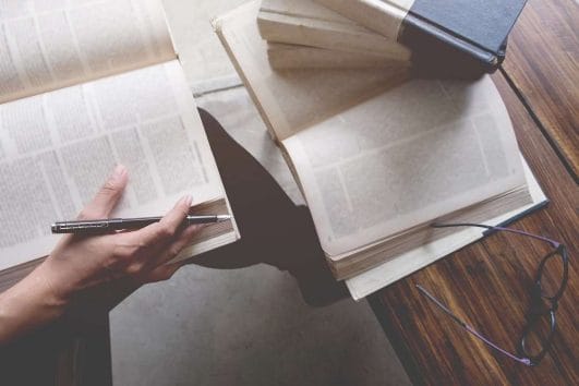 person reading book and writing
