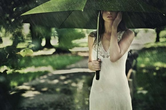 woman standing below umbrella in rain term life insurance