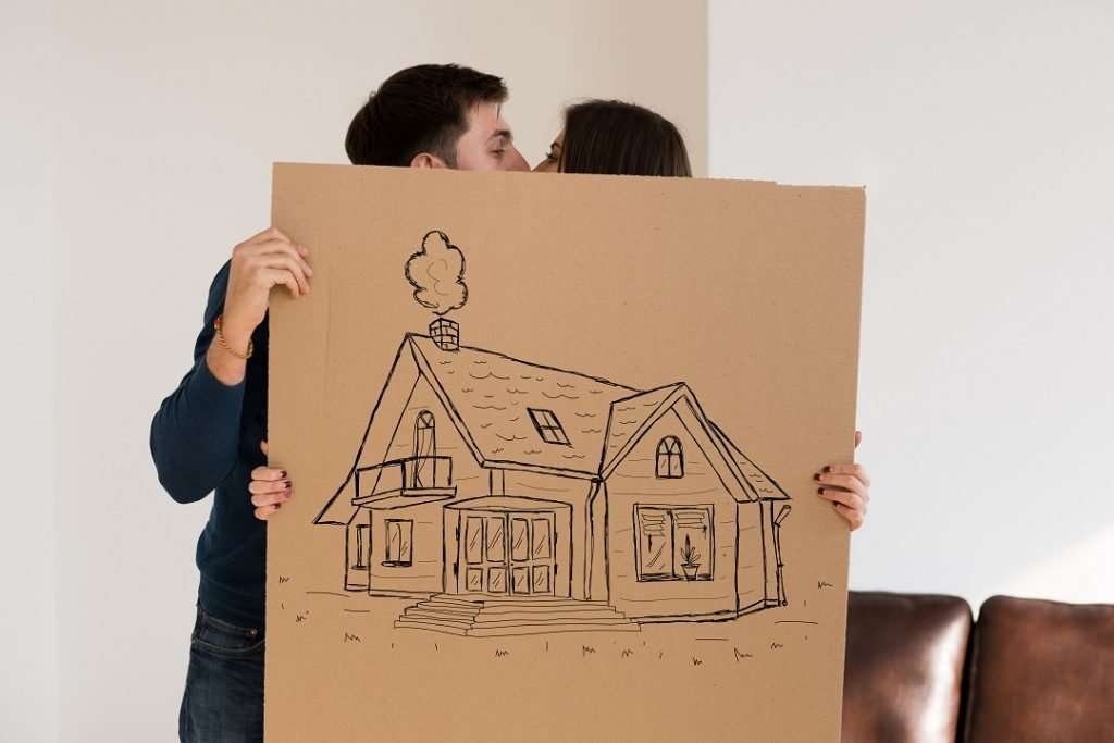couple kissing over down payment of house
