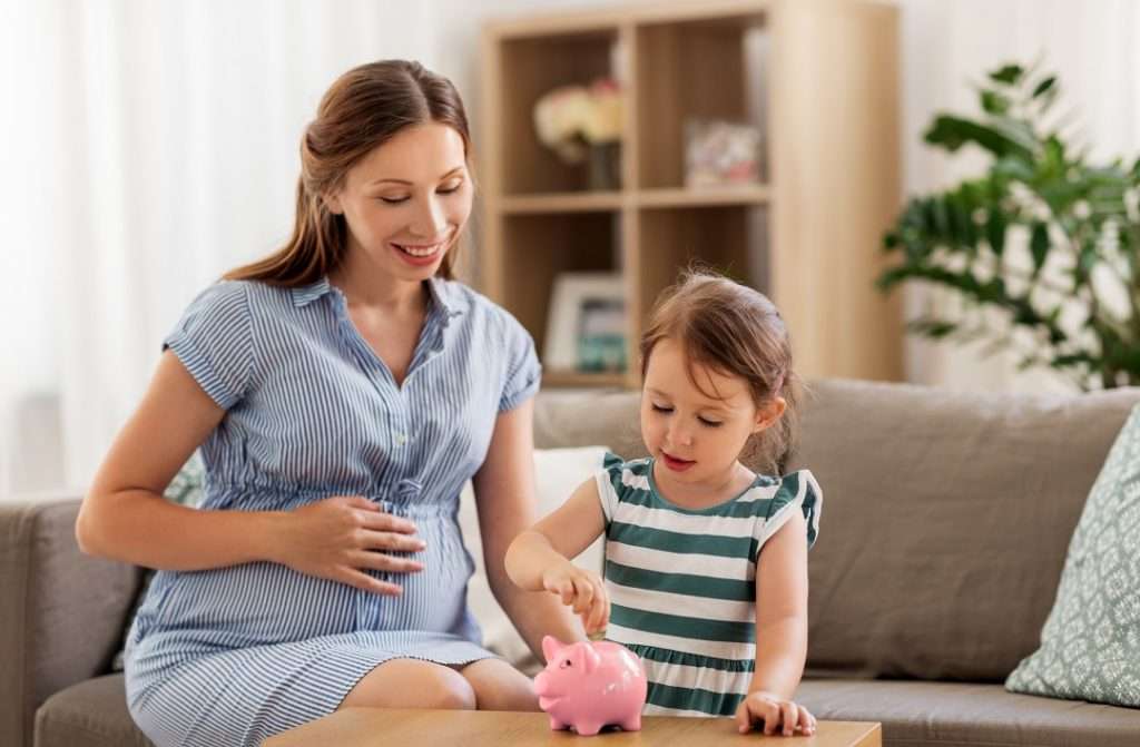 A mother and daughter using a piggy bank