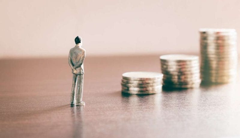 Man standing in front of stacks of coins