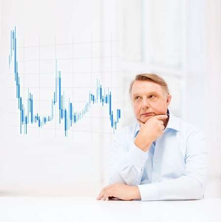 an older man sitting thinking about a stock chart
