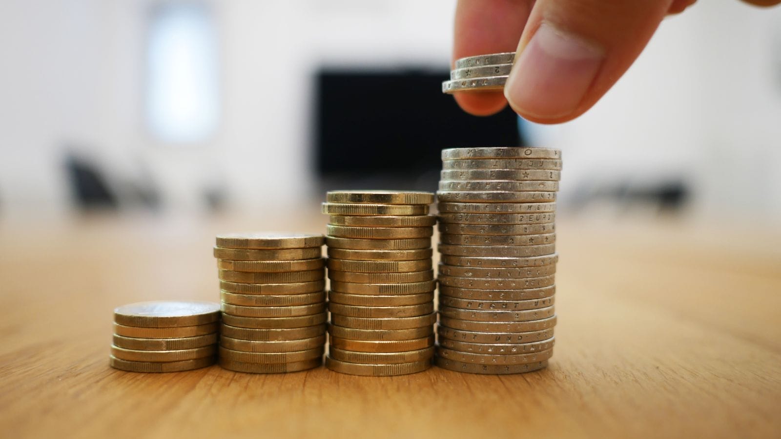 A person stacking coins higher and higher