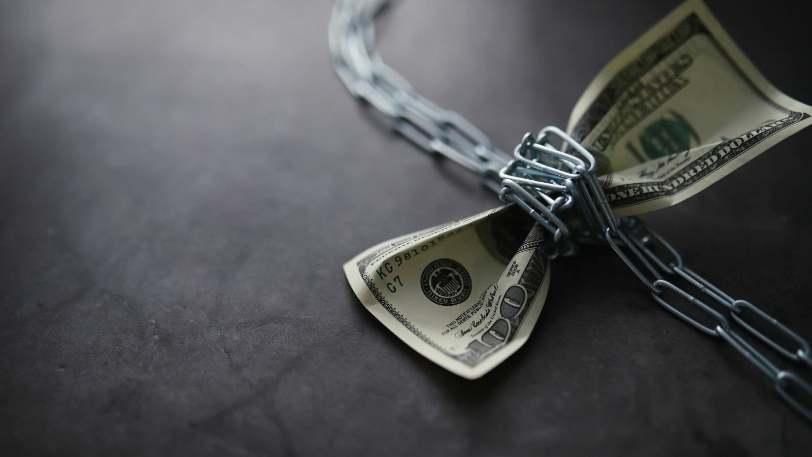 A dollar bill tied to a chain

