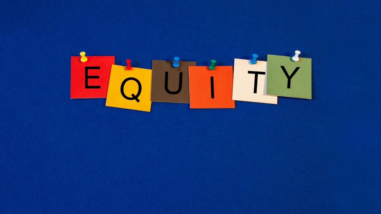 Several colorful papers attached to a blue board spelling the word equity

