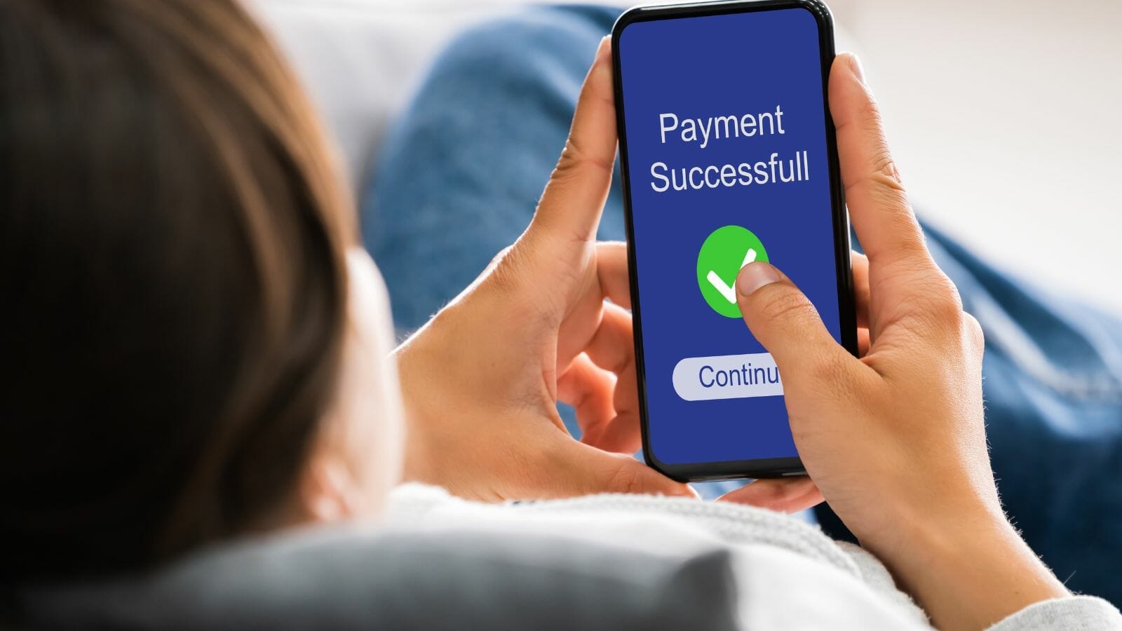 A person holding a phone that says payment successful

Description automatically generated
