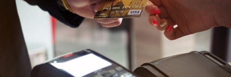 a person handing their debit card to a cashier