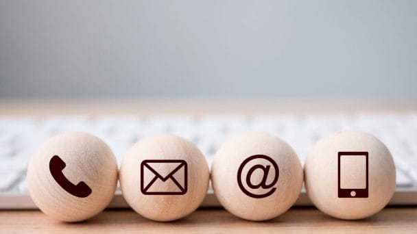 wooden balls showing symbols for phone, email, at, and phone