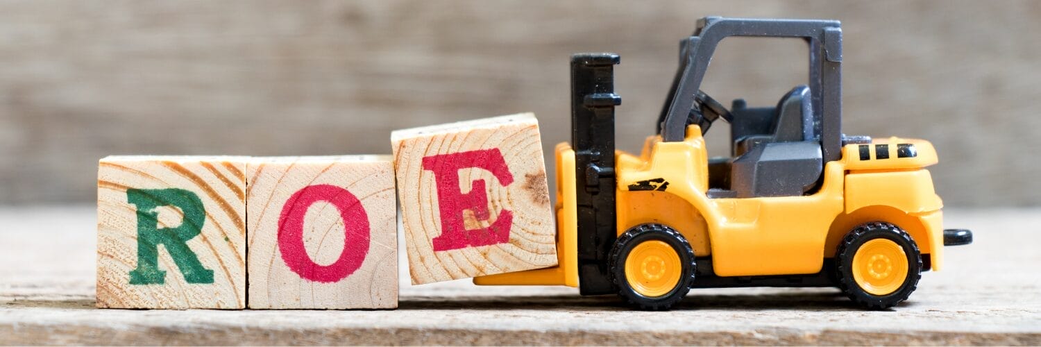 A toy forklift lifting a wood block with an "E" on it next to blocks with "R" and "O" on them