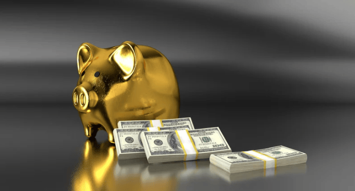 a gold piggy bank next to money