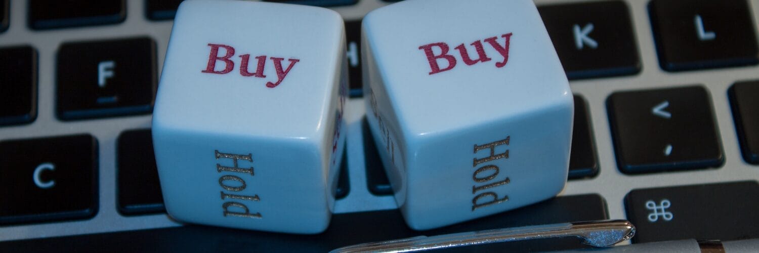 A closeup of dice saying buy and buy