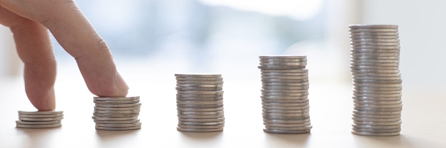 A hand holding a stack of coins
Description automatically generated with low confidence
