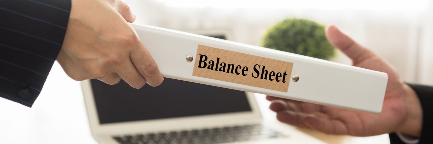 a person handing a binder labeled "Balance Sheet" to another person