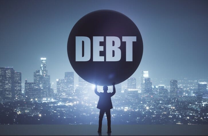 A person holding up a circle that says debt