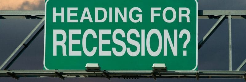a green sign with the phrase heading for recession? on it