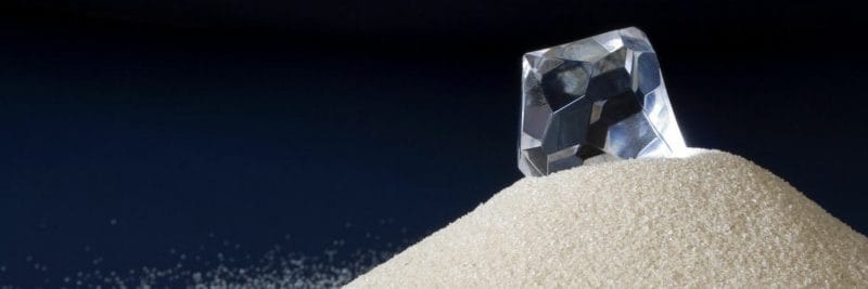 diamond sitting on a small hill of sand