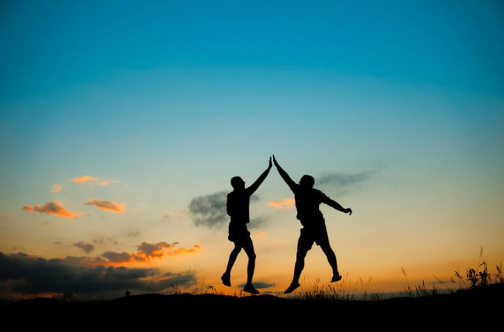 two people jumping and high fiving
