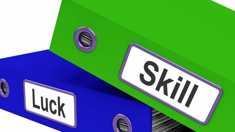 Close-up of a green and blue file folders with the words skill and luck on the side of each

