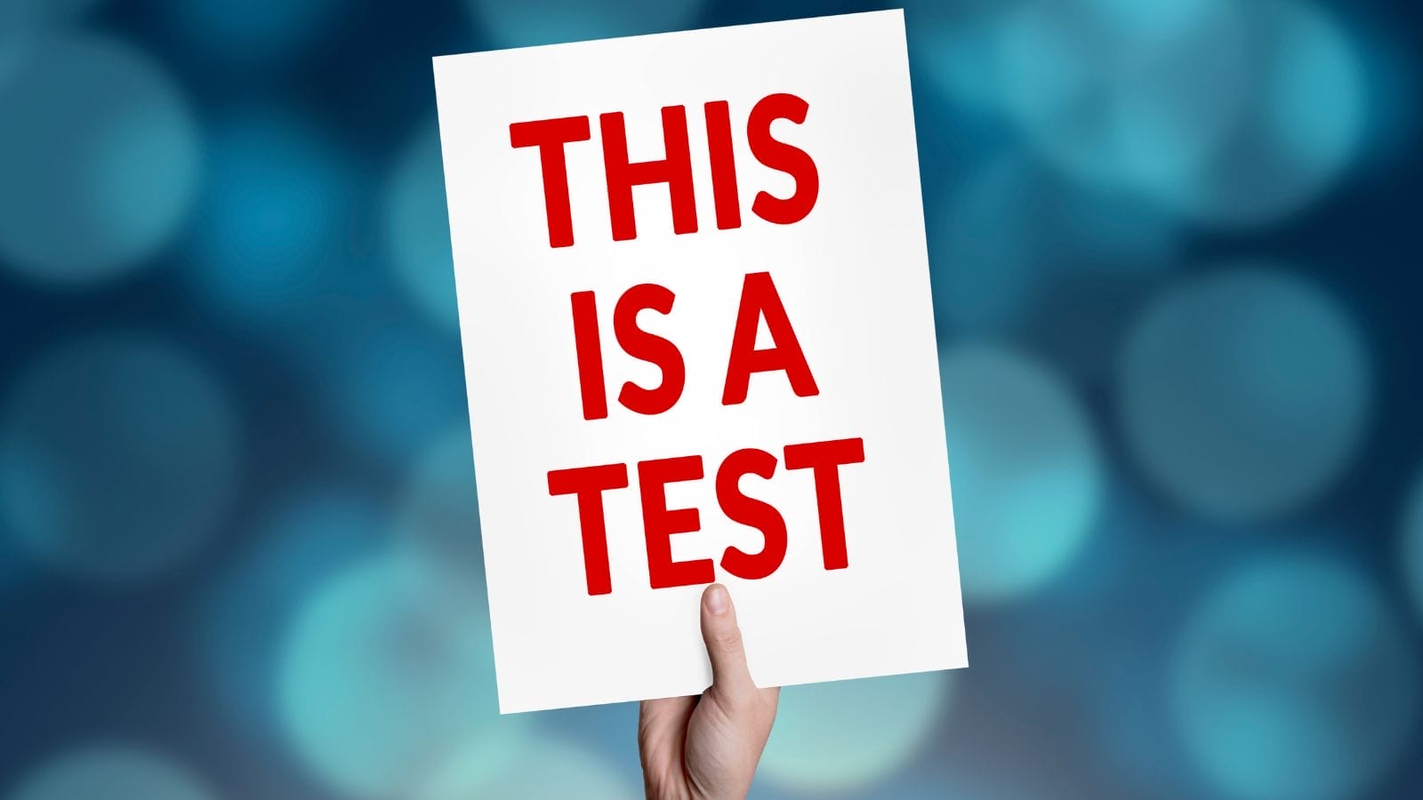 A hand holding a sign

Description automatically generated