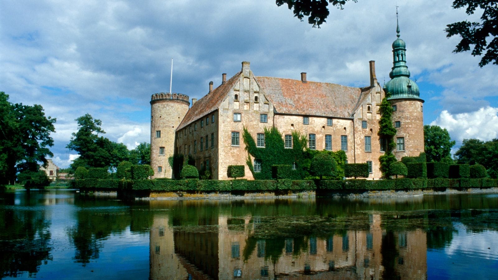 A large stone building with a tower and a moat