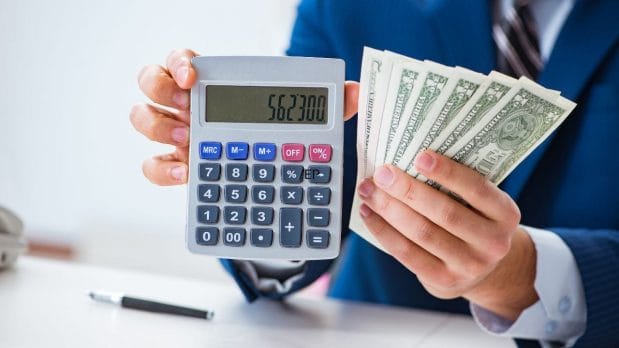 A person holding a calculator and money