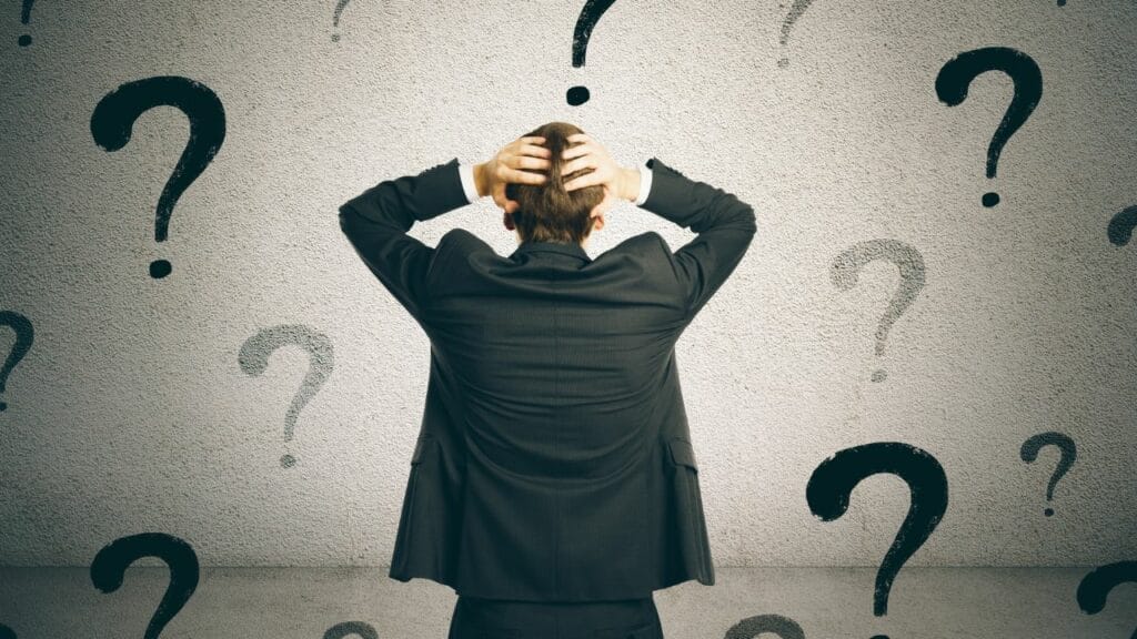 A person stressed surrounded by quest marks