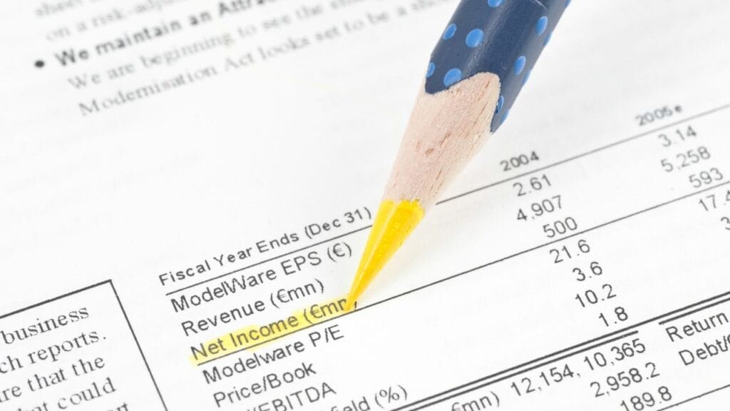 a person highlighting net income on a balance sheet with a yellow pencil